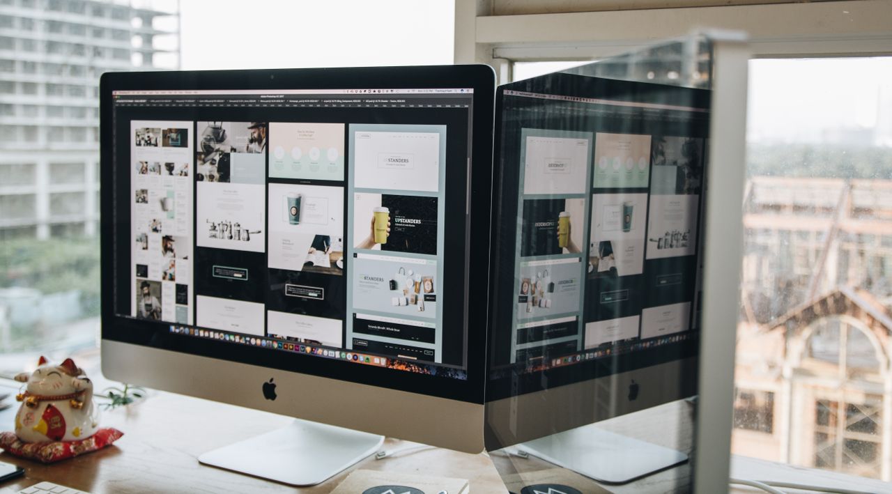 Deux écrans posés sur un bureau, illustrant le web design dans un environnement de bureau moderne.